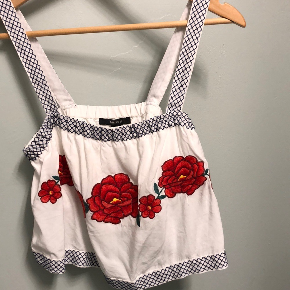 White crop top with roses and black stitching.